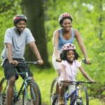 African American family cycling on a forest trail.