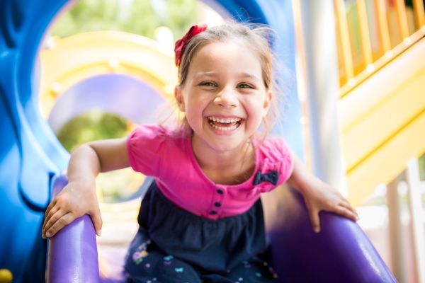 Young girl smiling on slide