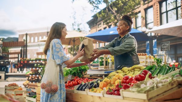 Woman purchasing goods at a farmer's market stand