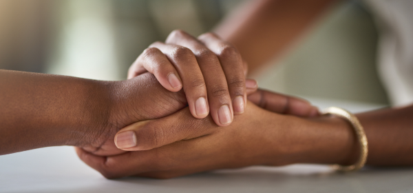 Closeup of two people holding hands