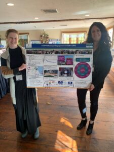 Two people holding an academic poster