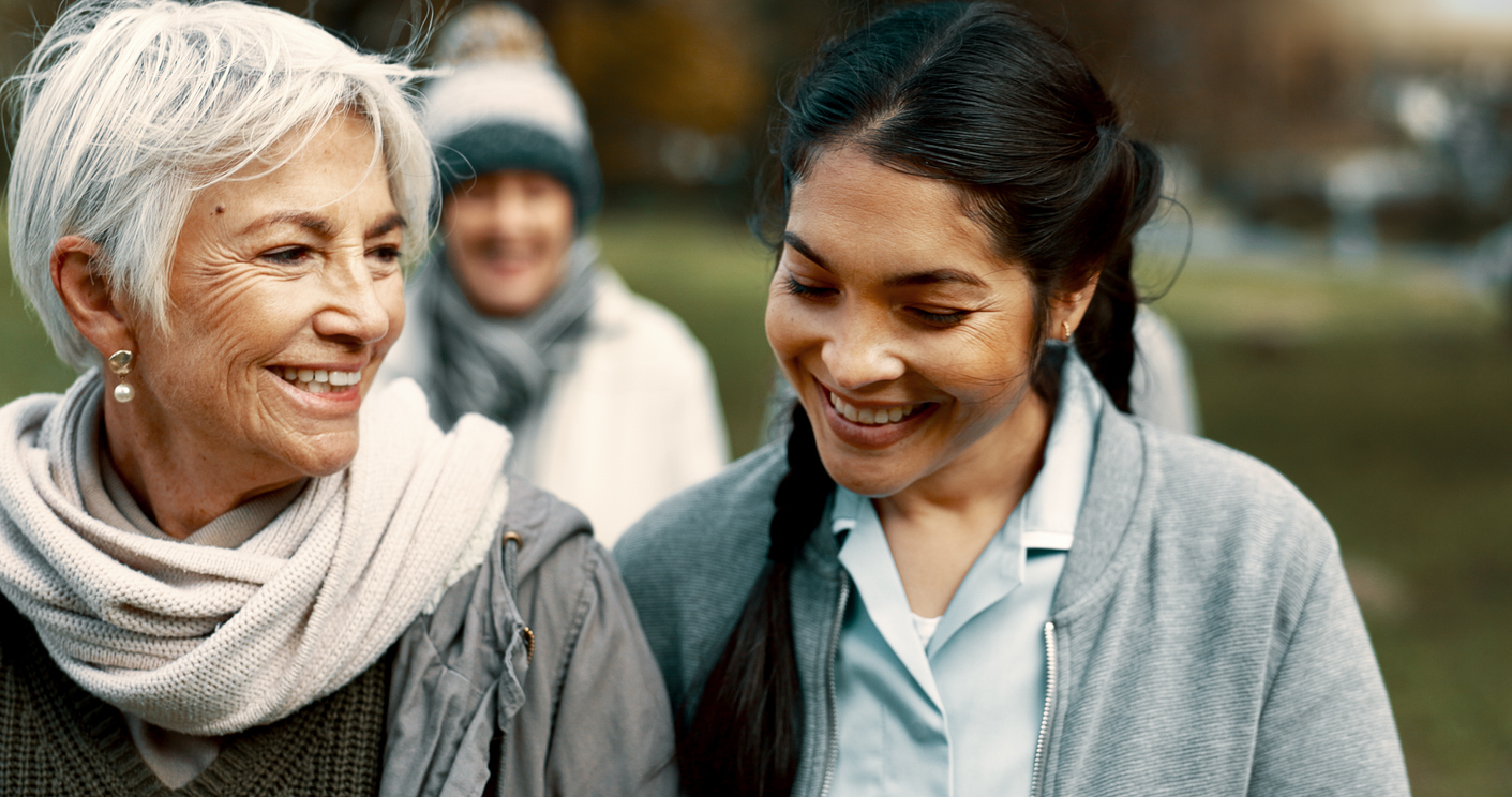 older woman smiling and walking with younger woman