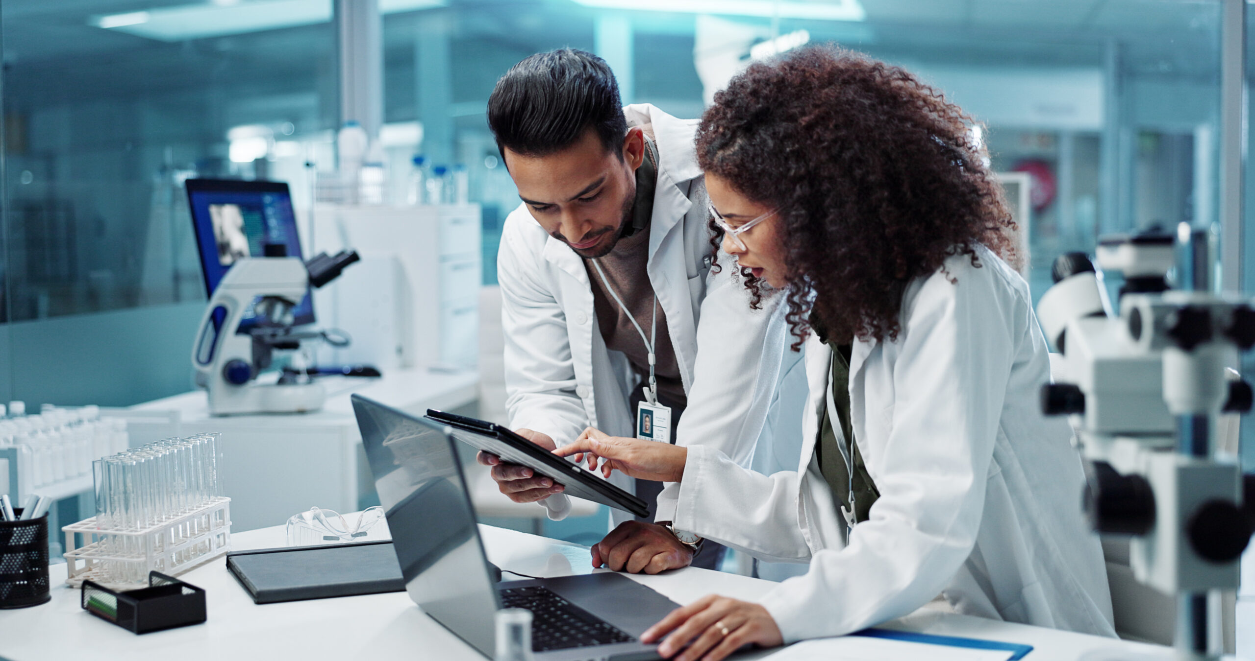 Two scientists looking at a tablet computer in a laboratory